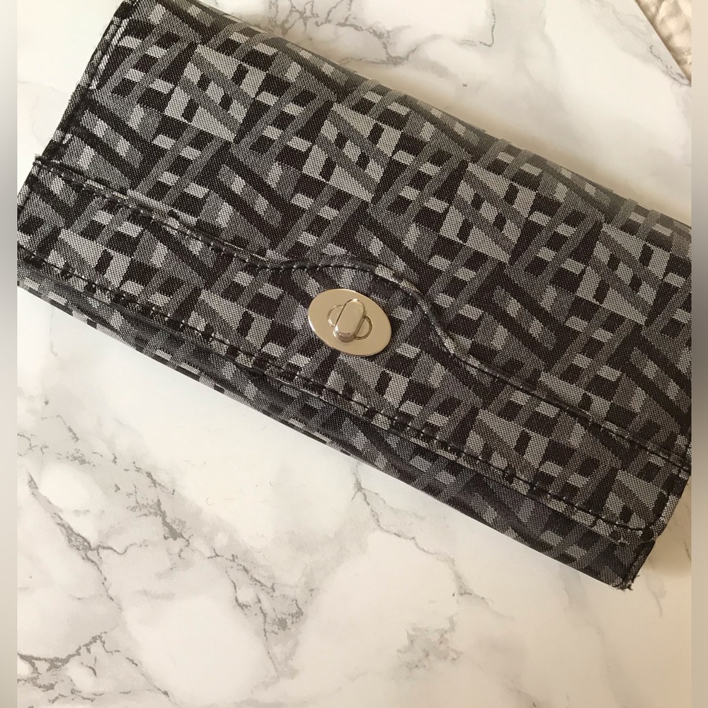 Black and gray patterned wallet with zipped compartment on back of wallet.